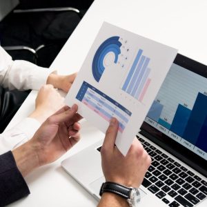 Business professionals discussing data charts and graphs in a modern office setting.